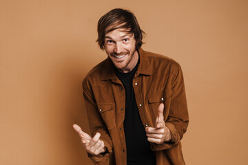 White unshaven man smiling and pointing fingers at camera