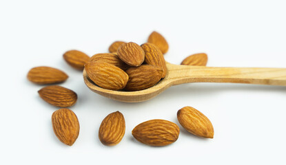 Almond nuts in wooden spoon isolated on white background. Close-up. Banner. Selective focus.