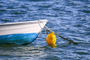 Petite barque sur son mouillage, amarrée à sa bouée jaune
