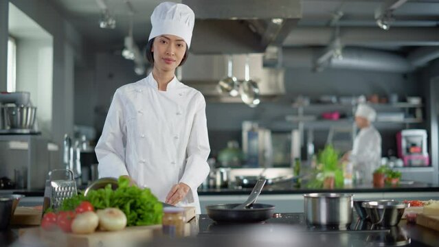 Modern Kitchen Restaurant: Portrait of Asian Female Chef, Crossing Arms and Looking at Camera Smiles. Professional Cooking Delicious and Authentic Food, Cuts Vegetables, Preparing Healthy Meal