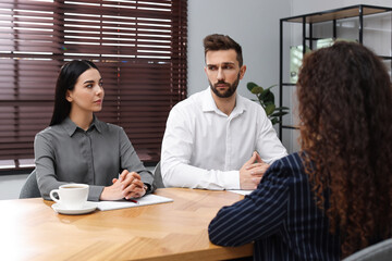 Coworkers conducting job interview with African American woman in office. Racism concept