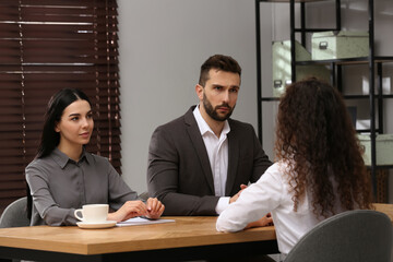 Coworkers conducting job interview with African American woman in office. Racism concept