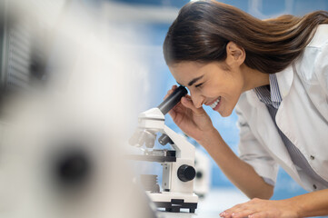 Profile of woman looking through microscope