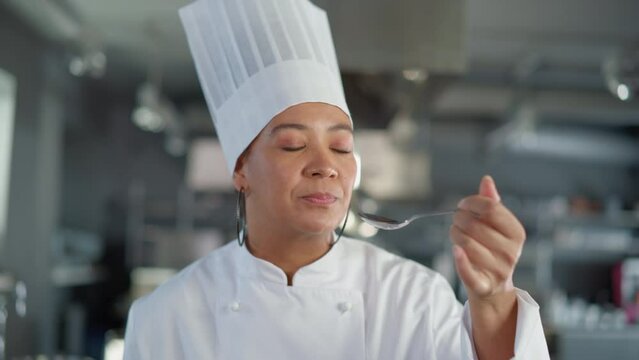 Restaurant Kitchen: Portrait of Black Female Chef Preparing Dish, Tasting Food and Enjoying it. Professional Cooking Delicious, Authentic, traditional Food, using Healthy Ingredients for Meal Recipe