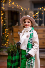 Christmas time.A girl in town with gifts. December, decorated streets with Christmas trees and lights.