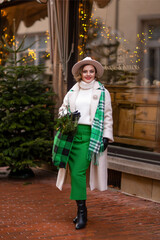 Christmas time.A girl in town with gifts. December, decorated streets with Christmas trees and lights.