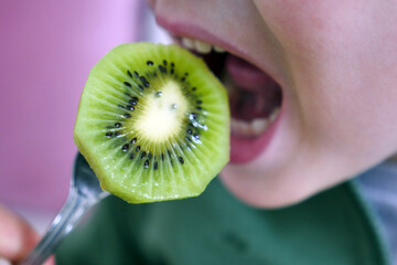 a sliced kiwi slice,close-up kiwi slice,a person eats kiwi fruit,