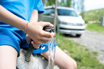 child playing with water from a fountain