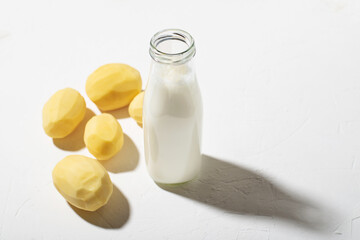 Potato milk concept. Bottle with potato milk on a white background. An alternative to animal products. Vegan food.