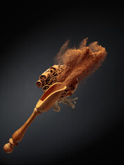 Cinnamon powder is poured out of the wooden spoon.