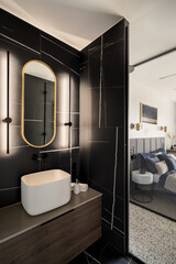Led lights by oval mirror in modern bathroom