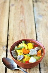 Mexican Beef Soup. Latin American soup with beef, potatoes, carrots, corn on the cob, green beans, peppers, Beef Broth,
copy space, place for text, country style 