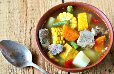 Mexican Beef Soup. Latin American soup with beef, potatoes, carrots, corn on the cob, green beans, peppers, Beef Broth,
copy space, place for text, country style 