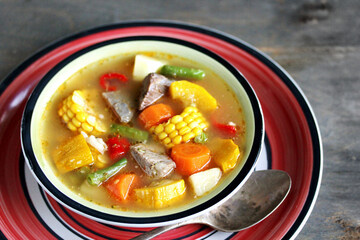 Mexican Beef Soup. Latin American soup with beef, potatoes, carrots, corn on the cob, green beans, peppers, Beef Broth,
copy space, place for text, country style 