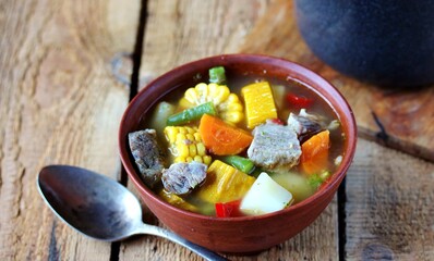 Mexican Beef Soup. Latin American soup with beef, potatoes, carrots, corn on the cob, green beans, peppers, Beef Broth,
copy space, place for text, country style 