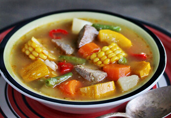 Mexican Beef Soup. Latin American soup with beef, potatoes, carrots, corn on the cob, green beans, peppers, Beef Broth,
copy space, place for text, country style 