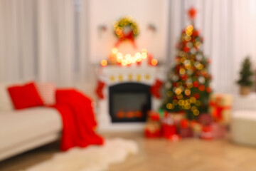 Blurred view of festively decorated room with Christmas tree, fireplace and sofa. Interior design