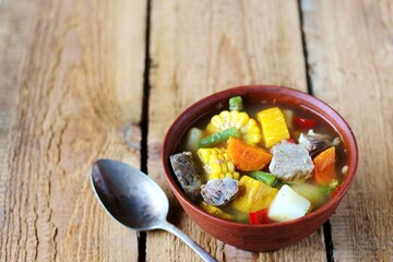 Mexican Beef Soup. Latin American soup with beef, potatoes, carrots, corn on the cob, green beans, peppers, Beef Broth,
copy space, place for text, country style 