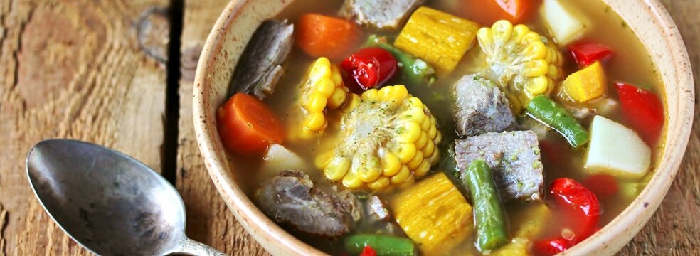 Mexican Beef Soup. Latin American soup with beef, potatoes, carrots, corn on the cob, green beans, peppers, Beef Broth,
copy space, place for text, country style 