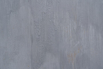 Fragment of an old metal wall. Gray paint is laid unevenly, there are pockets of corrosion....