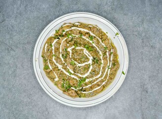 chicken makhni handi in white plate top view indion food on dark grey background