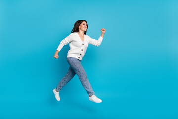 Fototapeta na wymiar Photo of shiny pretty lady dressed white cardigan jumping high running fast isolated blue color background