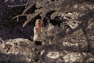 girl staying in snow bushes in sweater