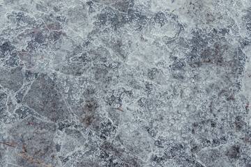 Cracked ice on concrete with yellow leaves. Yellow leaves and co