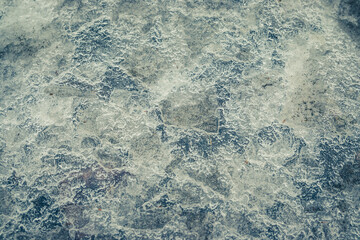 Cracked ice on concrete with yellow leaves. Yellow leaves and co