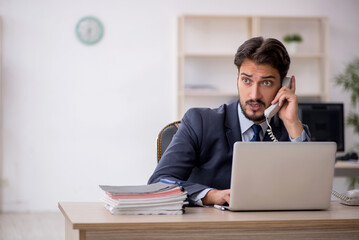 Fototapeta premium Young male employee working in the office