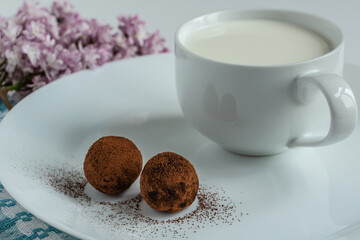 truffles with cocoa, a cup of fresh milk, delicious dessert