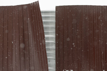 Broken fence. Steel fence buckled away from gusts of wind. Territory is fenced.