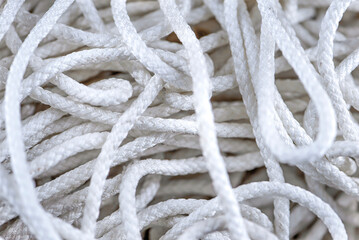 Thick tangled white rope close up. Close-up of an worn out boat rope as a nautical background.