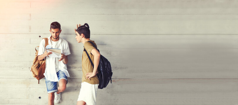 students friends on the wall of college or university