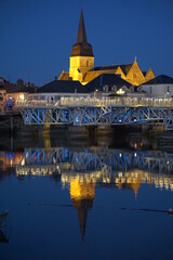 mirror reflection of old stone church at night in the harbor  in vendée on the atlantic coast, france