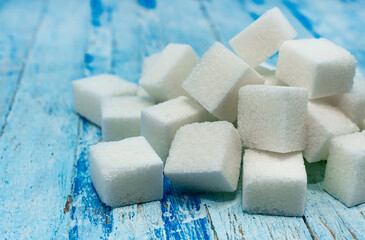 Sugar cubes. Refined sugar scattered on a wooden surface close-up