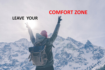 Leave your comfort zone. Person from behind with hands up in mountains. Motivation call to action
