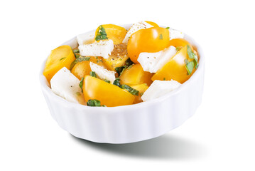 Yellow tomatoes basil pepper mozarella salad in a bowl on a white isolated background