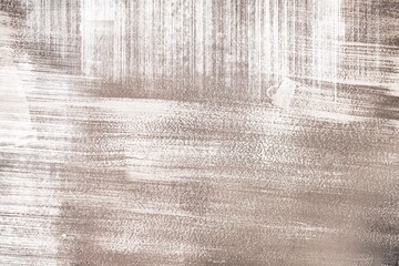 Grunge shabby background with stripes of dry white paint on brown craft paper. Texture with brush...