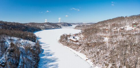 Aerial drone view of the snow-covered and frozen Cheat River flowing through the mountains towards...