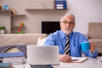 Old male employee working from home during pandemic