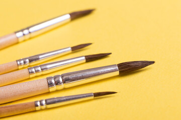 Paint brushes isolated on  yellow background. For art