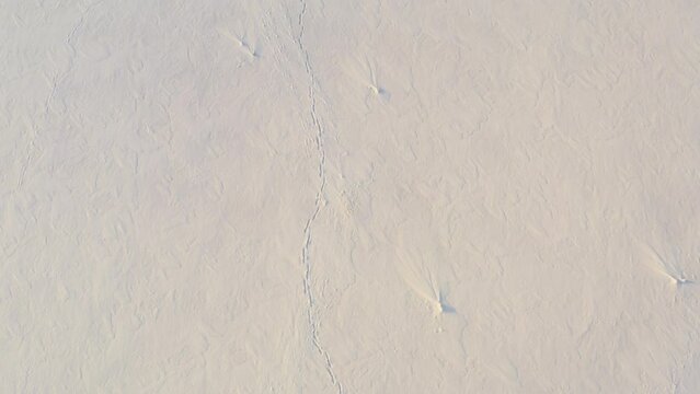 Rescue drone looks for footprints on the snow surface. Rescue operation in the mountains. Search for missing people in winter. Helicopter is looking for traces of border trespassers in the fresh snow.