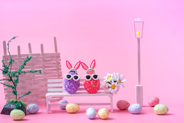 Closeup on a pink background multi-colored eggs on a white bench. Easter background, postcard, banner.