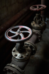 Industrial pair of valves ventil with flanges closeup selective focus over dark industrial...