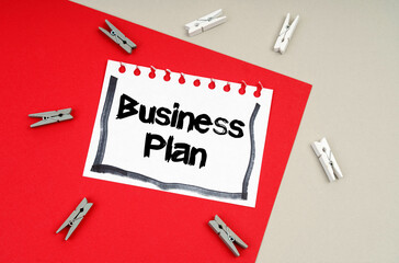 Clothespins and a sheet of notebook with the inscription - Business Plan