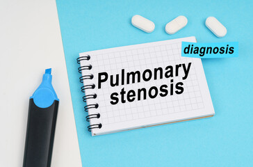 On a white and blue surface are pills, a marker and a notebook with the inscription - Pulmonary stenosis