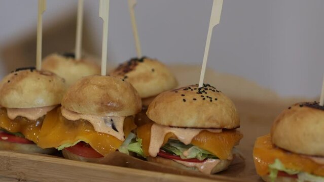 miniburgers on a wooden tray. snacks on the table, catering concept. 