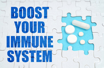 On the puzzles there is an inscription - Boost your Immune System, on a blue background pills.