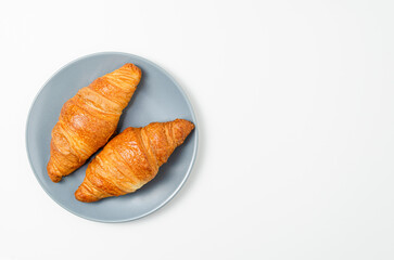 croissants on the plate on gray background. Top view.